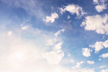 Wall Mural - Beautiful white small soft fluffy clouds on a pale blue sky background. Sky with sun glare