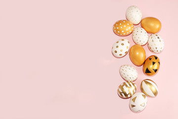 Decorated golden easter eggs isolated on pink background. Minimal easter concept. Happy easter background with copy space, place for text. Creative painting of eggs at home.