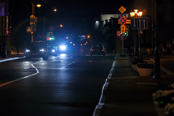 Wall Mural - view of city night road with cars standing on crossroad. car lights shining bright