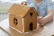process of creating a gingerbread house. young woman makes a gingerbread house