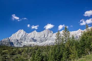 Wall Mural - bright blue sky near a glacier in the alps at the dachstein glacier look into a valley of hiking trails