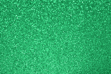 Wall Mural - Green glitter texture background. Defocused sparkle bokeh lights. Shiny festive holiday backdrop