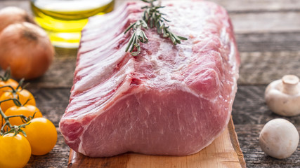 Wall Mural - Raw chop meat on wooden cutting board with ingredients for cooking