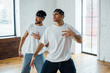 © LIGHTFIELD STUDIOS - handsome multicultural dancers in headbands gesturing and posing while dancing hip-hop