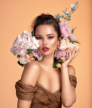 Attractive Brunette Girl With Big Beautiful  Bouquet Of  Flowers. Beautiful White Girl With Flowers.  Pretty Woman With Bright Makeup. Art Portrait With Flowers.