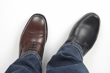 Men's feet in different color classic shoes on white background