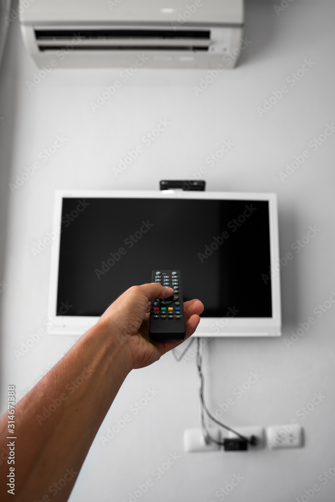 The man with the remote control in hand want switch on the TV and ...