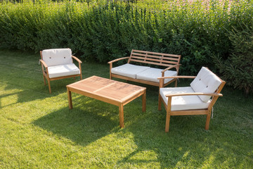 Set of wooden garden furniture. Table and chairs with pillows at the garden