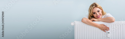Cuadros en Lienzo Woman In Sweater Leaning On Radiator