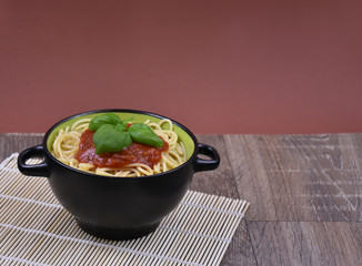 Spaghetti pasta with tomato sauce on wooden table stock images. Bowl of spaghetti. Spaghetti with basil on a wooden background with copy space for text