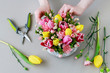 canvas print picture - Woman shows how to make beautiful floral arrangement with tulip and carnation flowers