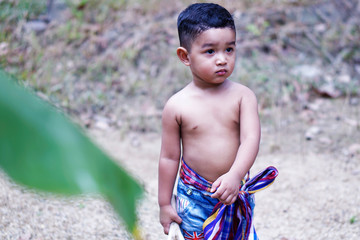 Happy baby child sitting on rural road, behind kid embrace life, dreamlike evening light, slow motion, innocent and pure love concept.                                                          