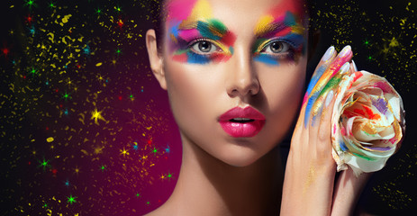 beautiful girl with festive bright multi-colored make up on the face. young woman dressed in extrava