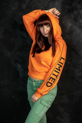 red-haired girl in bright orange clothes with a hood