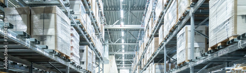 Fotografía Rows of shelves with boxes in modern warehouse
