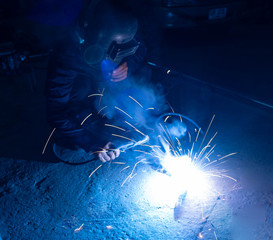 Wall Mural - The welder is welding the various parts of the house construction.