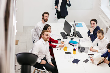 Wall Mural - brainstorming of young caucasian people, handsome good-looking business leaders gathered to work together and realize their joint creative project