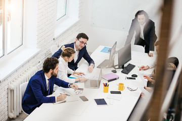 Wall Mural - friendly business team in boardroom, in modern office gathered to discuss, have conversation about business strategies, ideas and projects. brainstorm of diverse young caucasian people in formal wear