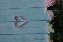 White Roses With Pink Edges And A Ribbon Heart On A Blue Background.