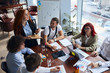 © alfa27 - Young caucasian creative people sitting at table in modern office and discussing new projects together