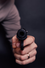 Male hand with gun isolated on black background. Man with a gun ready to shoot, focus on the weapon.