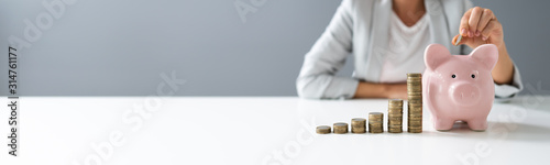 Fotomural Person Inserting Coin In The Piggybank