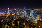 Fototapeta Miasto - Warsaw, Poland. 03. December. 2019. Drone shot at night metropolis with skyscrapers and buildings. Aerial view of the business center at night in winter. Warsaw,