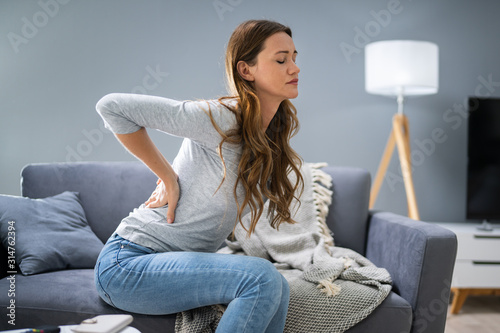Fotografía Woman Having Backache While Sitting On Sofa