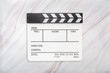 Flat lay of white clapboard on marble background. Clapper board on marble texture. Top view