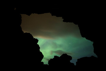 Wall Mural - Aurora Borealis (Northern Lights) above a cave entrance