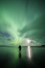 Wall Mural - Aurora Borealis (Northern Lights) above a person at Stokksnes Beach and Vestrahorn Mountains, Iceland