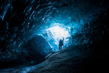 Female Explorer Standing Inside Ice Cave Tunnel, Iceland