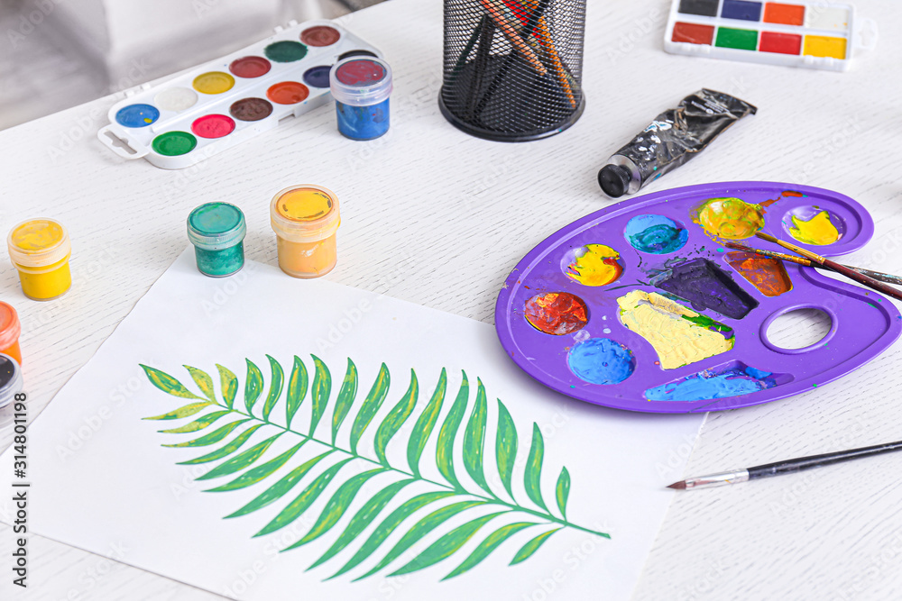 Beautiful painting with supplies on workplace