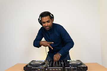 Wall Mural - Male DJ playing music on white background