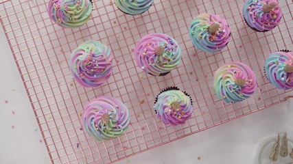 Wall Mural - Flat lay. Step by step. Frosting unicorn chocolate cupcakes with rainbow color buttercream frosting.