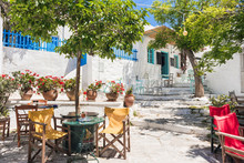 Beautiful Greek Street With Flowers And Cafe Tables In Amorgos Island, Greece
