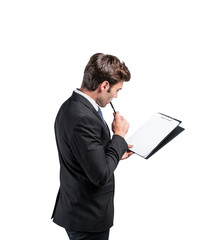 Wall Mural - Thoughtful businessman with clipboard, side view