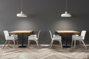 Square dining tables in gray cafe interior