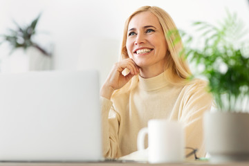 Poster - Freelance job concept. Middle-aged woman working on laptop