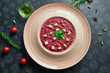 Homemade and fresh vegetarian risotto with beets and blue cheese. Italian traditional rice in a pink ceramic plate on a black background in a composition with ingredients. Close up view
