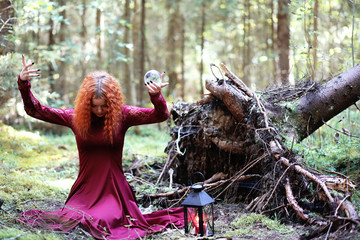 Wall Mural - The red-haired witch holds a ritual with a crystal ball