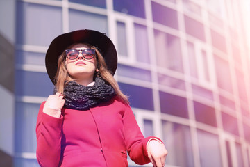 Wall Mural - Pretty girl on a walk in red coat in the city