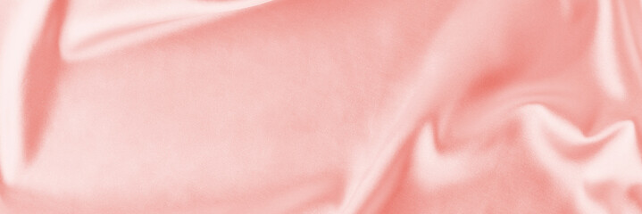 Light pink silk background with a folds.  Abstract texture of rippled satin surface, long banner
