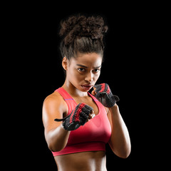 Wall Mural - Portrait of beautiful fighter woman over black background