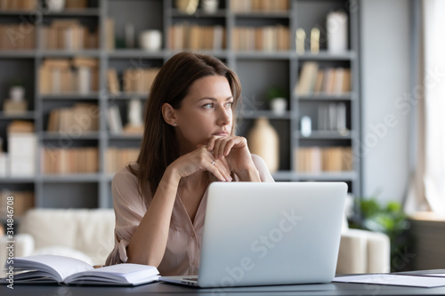 Fotomural Pensive young woman distracted from work thinking
