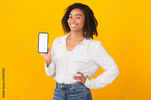 Fotomural Smiling afro woman showing new app on phone