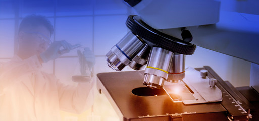 Wall Mural - laboratory concept; microscope with the blurred picture of a scientist is researching in the laborat