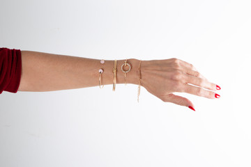 Wall Mural - Woman arm hands with gold bracelets in white background