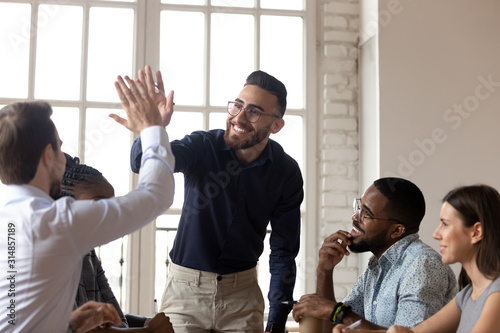 Smiling multiethnic male colleagues celebrate shared success Tableau sur Toile