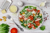 Healthy Caesar Salad with salted salmon (trout), iceberg or lettuce, Parmesan Cheese, tomatoes, bread Croutons and gourmet sauce. Selective focus, top view and copy space